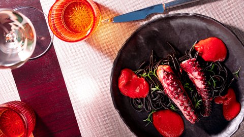 Octopus with tomato, on black pasta