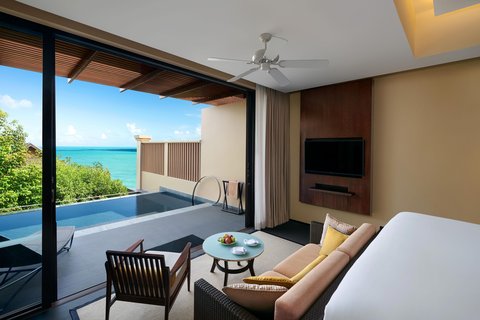 Habitación de un dormitorio con piscina y vista al mar_Sala de estar